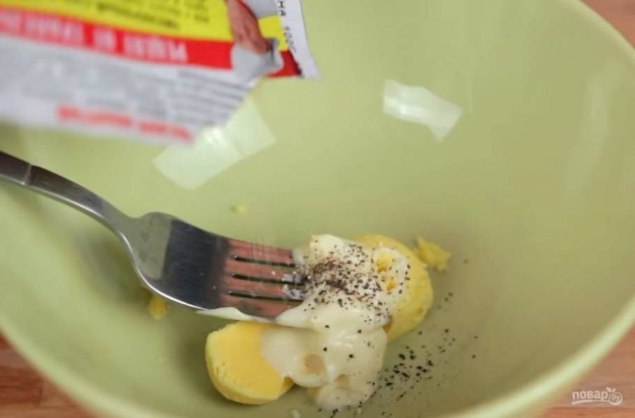 1. Для начала отварите яйца и разрежьте их пополам так, чтобы желток получился посредине. Далее выньте желток одного яйца, смешайте его с майонезом и приправами (у меня это перец и сушеный чеснок) и выложите обратно в белковую основу. 