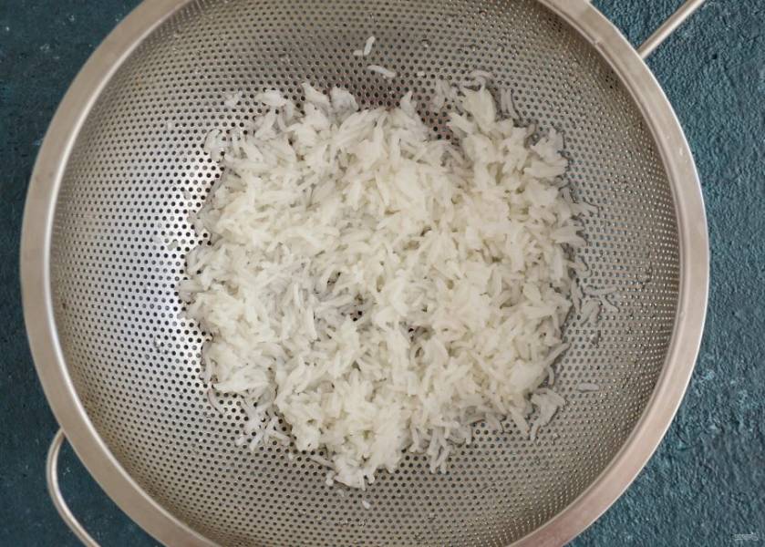 Откиньте рис на сито и промойте под водой. 
