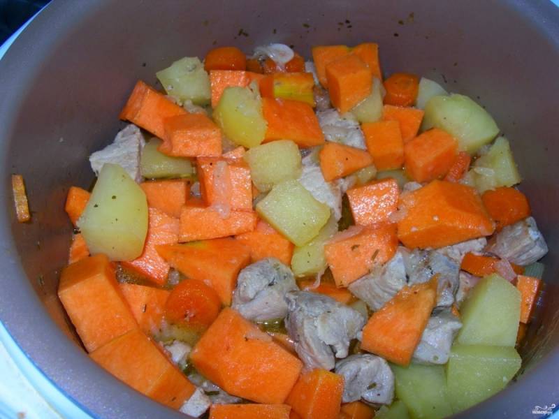Обжаренное мясо переложите в мультиварку к луку и морковке. Включите режим "Тушение" на час, влейте приблизительно стакан воды (можно использовать овощной бульон), чтобы покрывала мясо. 
Спустя 30 минут добавьте картошку и тыкву. 