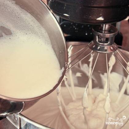Не прекращая взбивать, постепенно вводим в массу теплую молочную смесь.
