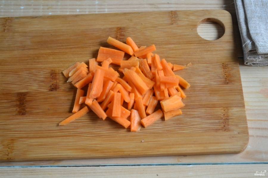 Приготовьте начинку. Для этого морковку порежьте некрупной соломкой. Лук порежьте кубиком.