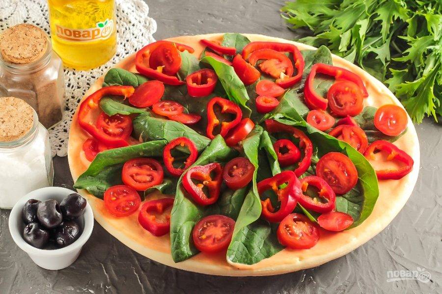 Промойте помидоры черри и болгарский перец. Из перца вырежьте сердцевинку и нарежьте овощи кружочками. Выложите на основу.