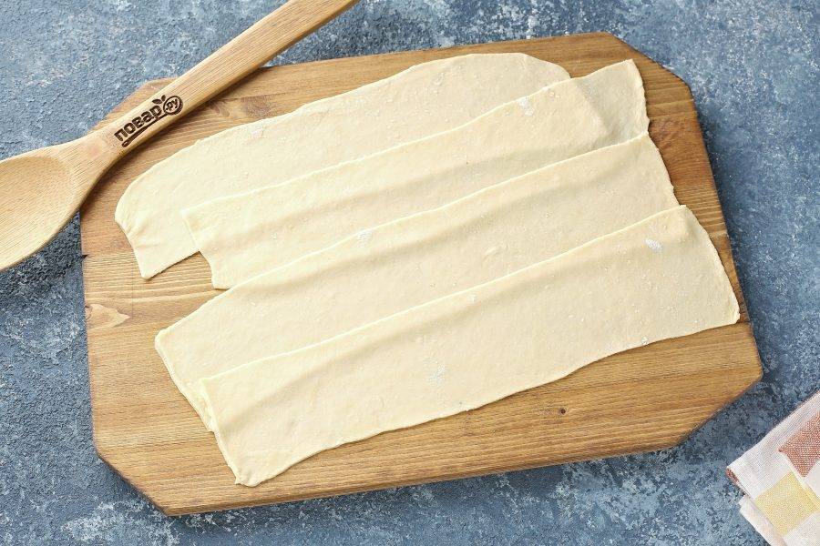 На присыпанной мукой поверхности, раскатайте тесто в тонкий пласт. Для удобства тесто можно разделить на 3-4 части. Нарежьте тесто длинными полосками, около 7-10 см. шириной.