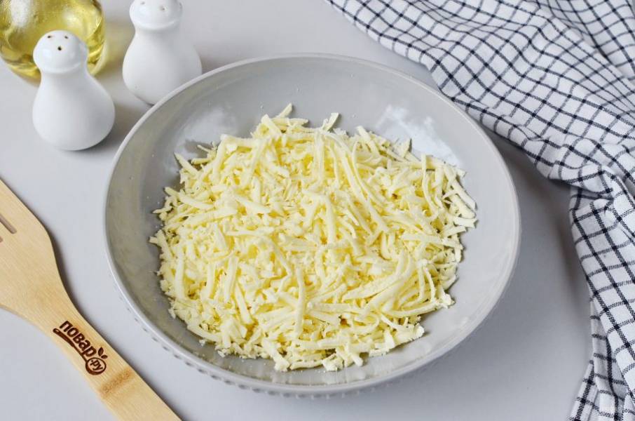 Натрите сыр на крупной терке. Выложите в большую и удобную миску.