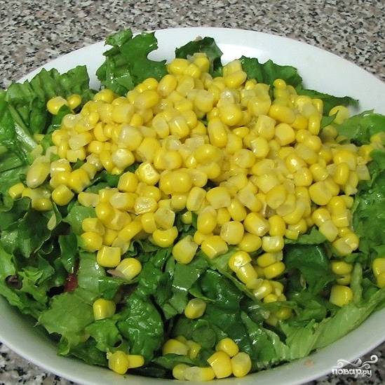 Добавляем в салат листья салата и кукурузу.