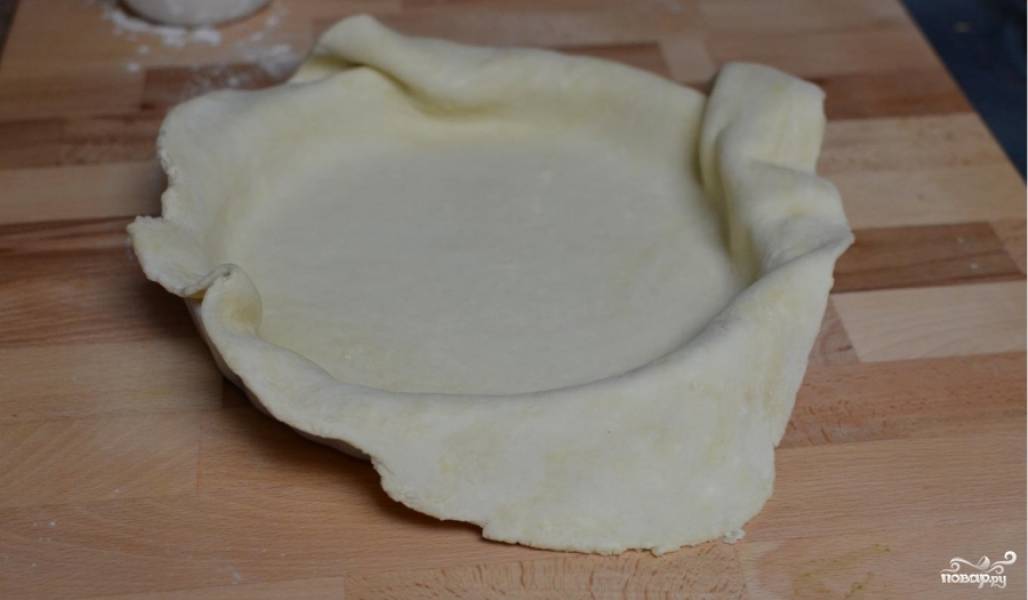 Смешайте сливочное масло, муку и одно яйцо, посолите. Замесите тесто и раскатайте его в большой блин, толщиной пол сантиметра. Уложите в форму для запекания пирогов.