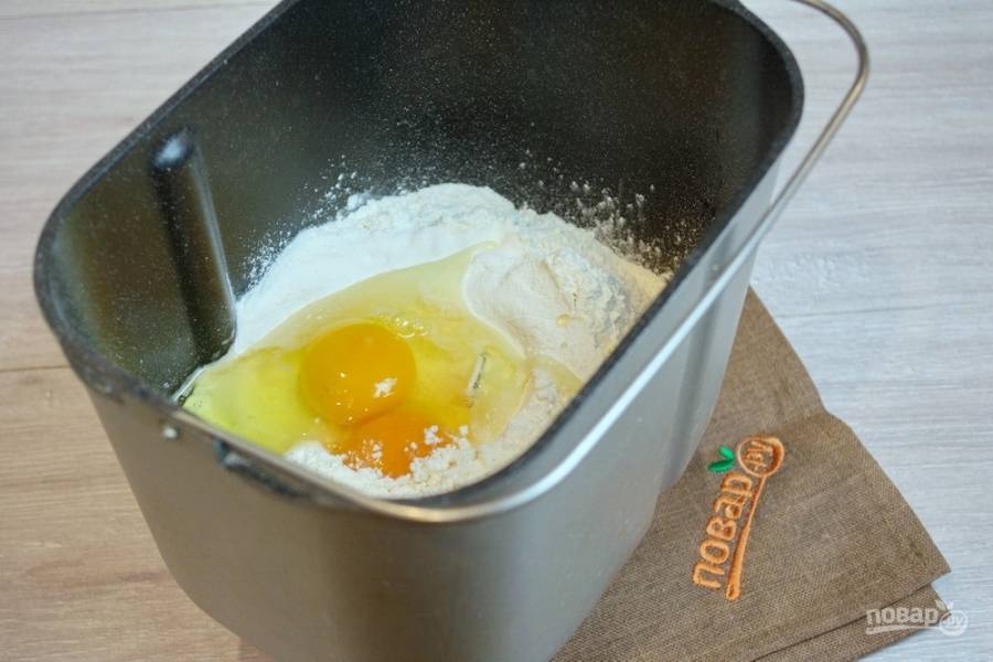 В чашу хлебопечки поместите муку. Добавьте яйца (3 желтка и 1 белок), сахар, соль, сухие быстродействующие дрожжи, сливочное масло, молоко, ваниль.
