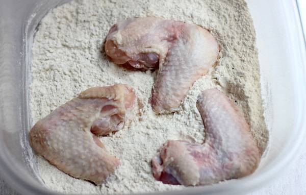2. Куриные крылышки вымыть, просушить и обвалять со всех сторон в панировке. При желании муку можно заменить сухарями. 