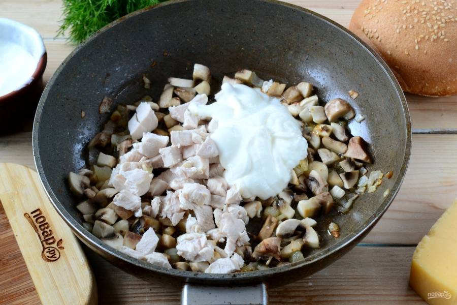 Отправьте курицу в сковороду к грибам, также добавьте пару столовых ложек сметаны. И, конечно, сейчас самое время посолить и поперчить по вкусу. Жарьте массу 5-7 минут.