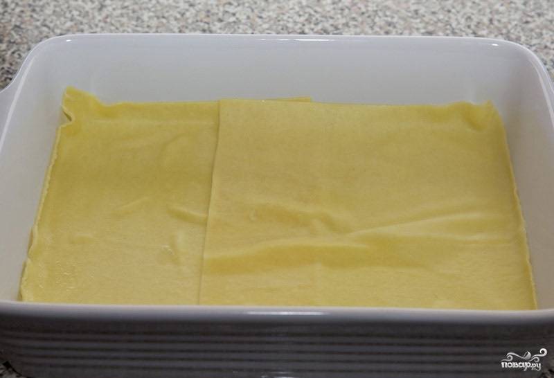 9. Теперь можно собирать наше блюдо. На дно жаропрочной формы выложите листы лазаньи. Если на упаковке не написано другое, то класть их надо сухими.