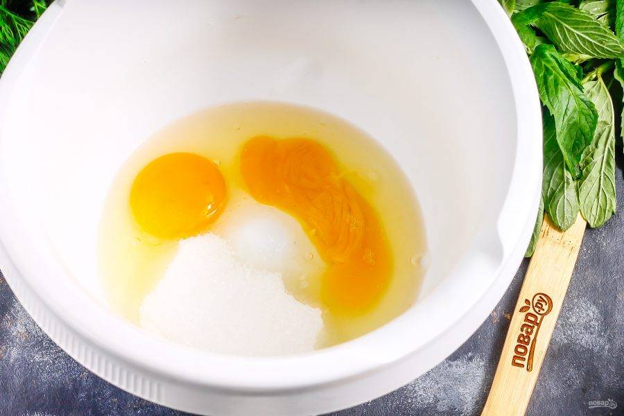 Куриные яйца вбейте в емкость кухонного комбайна или миксера, добавьте сахар и соль, взбейте в течение 4-5 минут в пышную пену.