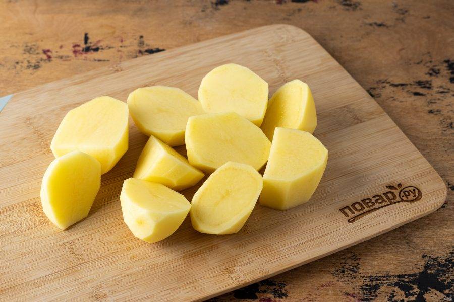 Картофель помойте, очистите от кожуры, разрежьте на 4-6 частей.