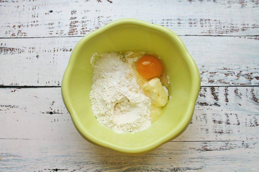 В миску просейте муку, разрыхлитель, всыпьте сахар, добавьте мягкое масло и разбейте яйцо.