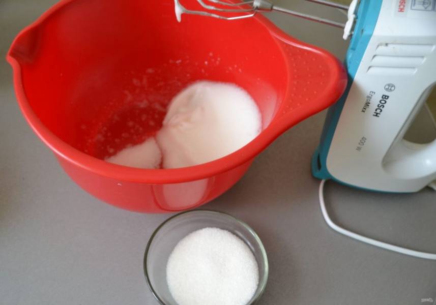 Взбейте яичный белок сначала в легкую пену, затем, постепенно добавляя сахар, взбейте до стойких пиков.
