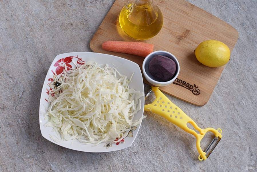 Капусту тонко нашинкуйте с помощью овощечистки и выложите в салатник.