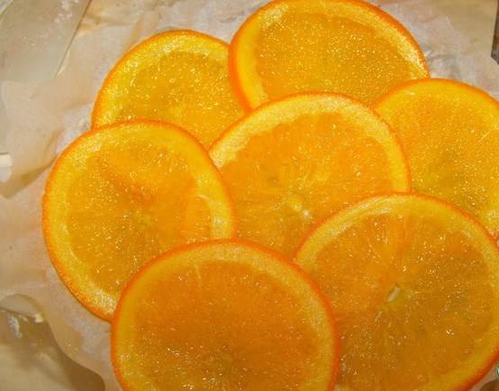 Смазать маслом и проложить бумагой для выпечки форму для торта диаметром 20 см. На дно уложить самые красивые кусочки апельсинов (около 7).