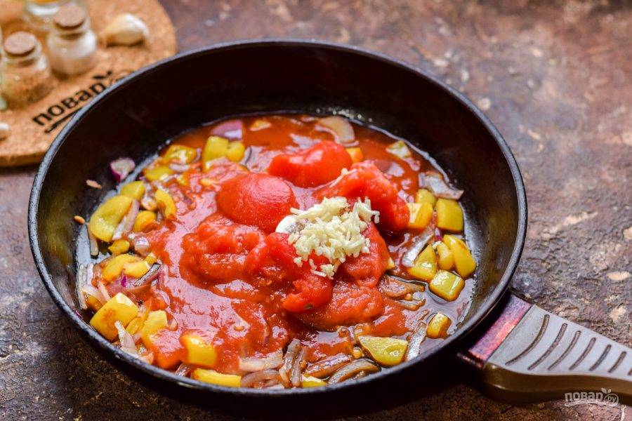 Добавьте в сковороду томаты в собственном соку. Чеснок очистите и натрите на мелкой терке, добавьте к томатам.
