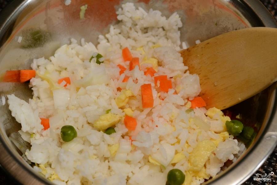 Нарежьте кубиками морковь и репчатый лук. Добавьте к рису вместе с зелёным горошком.