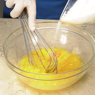 Поместите яйца в миску и взбейте их вместе с сахарной пудрой.