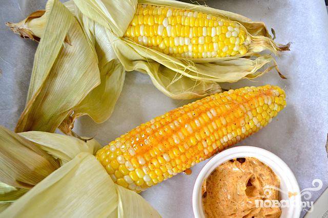 Достаньте кукурузу, аккуратно отогните шелуху и удалите кукурузные рыльца. Намазывать толстым слоем сверху соусом. Шелуха может служить ручкой во время еды. 