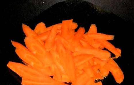 На сковороду с толстым дном кладем немножечко сливочного масла, добавляем остатки имбиря. Как только имбирь подрумянится, извлекаем его и  засыпаем морковь.
