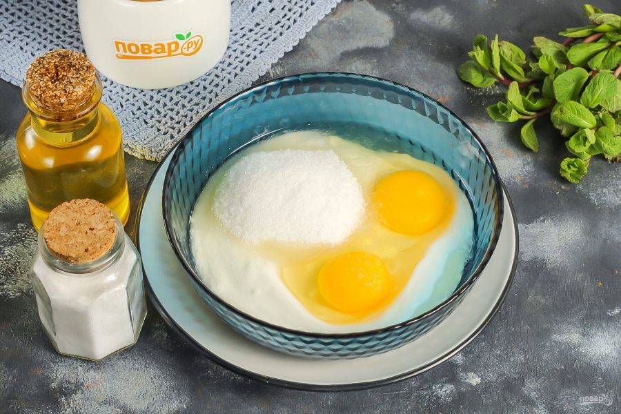 Сметану выложите в глубокую емкость: салатник или миску. Вбейте туда же куриные яйца, всыпьте соль и сахар. По желанию можете добавить немного ванильного сахара или другой ароматизатор. Все тщательно взбейте.
