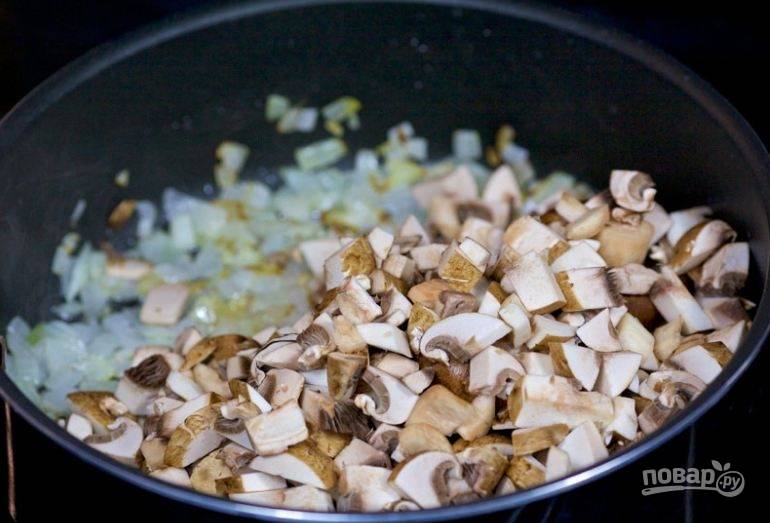 2. К обжаренному луку добавьте мелко нарезанные грибы.
