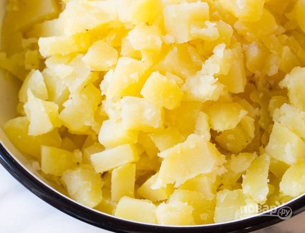 3. С картофеля слейте воду и остудите немного. Параллельно нарежьте кубиками яйца, измельчите сельдерей и лук. 