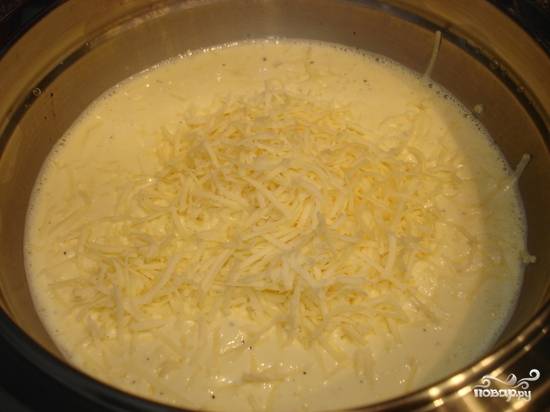 Сливки взбейте с яйцами. Натрите сыр на средней терке, добавьте его в эту смесь. Также всё посолите и поперчите. Перемешайте.