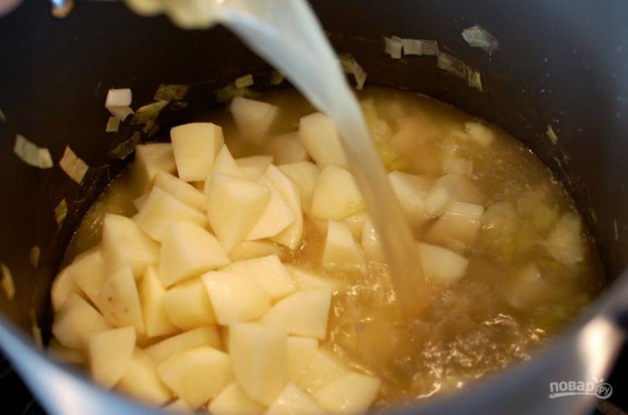 7.	Как только лук-порей станет более мягким, влейте в кастрюлю куриный бульон и добавьте в него картофель.