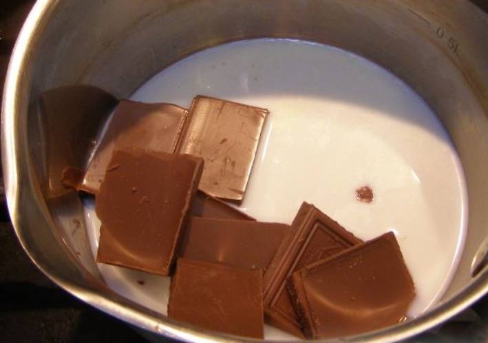 Прогрейте в сотейнике молоко, затем поместите туда шоколад и полностью его растопите.