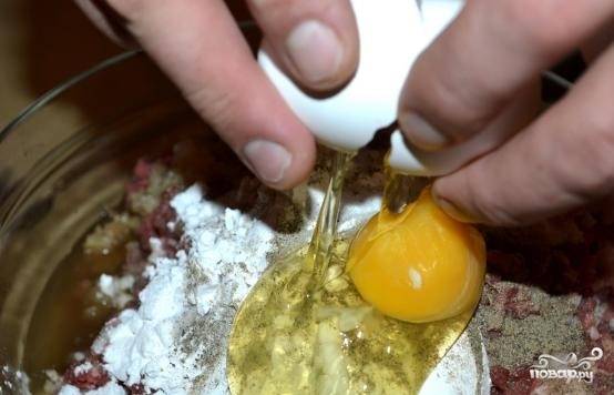 4. Добавьте в фарш одно сырое яйцо. Влейте коньяк – 3 столовые ложки; или замените на водку (в том же количестве). Все тщательно перемешайте.