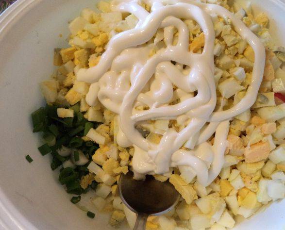 4. Шинкуем огурец и зеленый лук. Теперь смешиваем все ингредиенты. Заправлять салат можно майонезом или сметаной - по вашему вкусу.