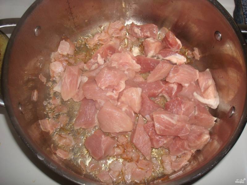Бекон придаст приятный аромат блюду. Затем влейте масло растительное, выложите к бекону мясо, порезанное кубиками. 