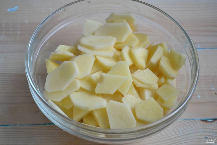 Очищенный картофель порежьте тонкими пластинами и посолите.
