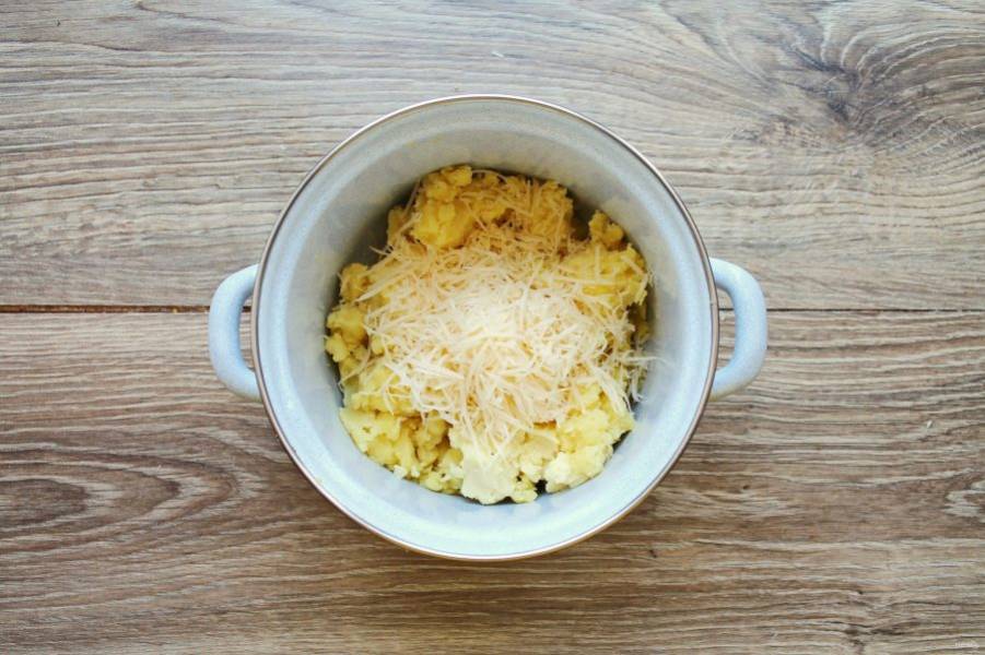 Сыр натрите на средней терке и выложите в кастрюлю с картофельным пюре.