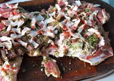 Бекон порезать на полоски и уложить на мясо.