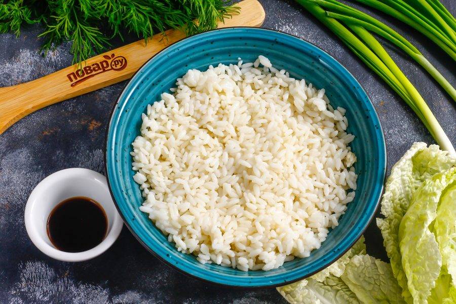 Выложите часть отварного риса в пиалу или глубокую тарелку, аккуратно разровняйте.