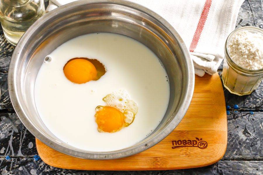 Вбейте куриные яйца в глубокую емкость, туда же влейте молоко любой жирности, но комнатной температуры. Всыпьте сахар, соль и взбейте все венчиком примерно 1-2 минуты.