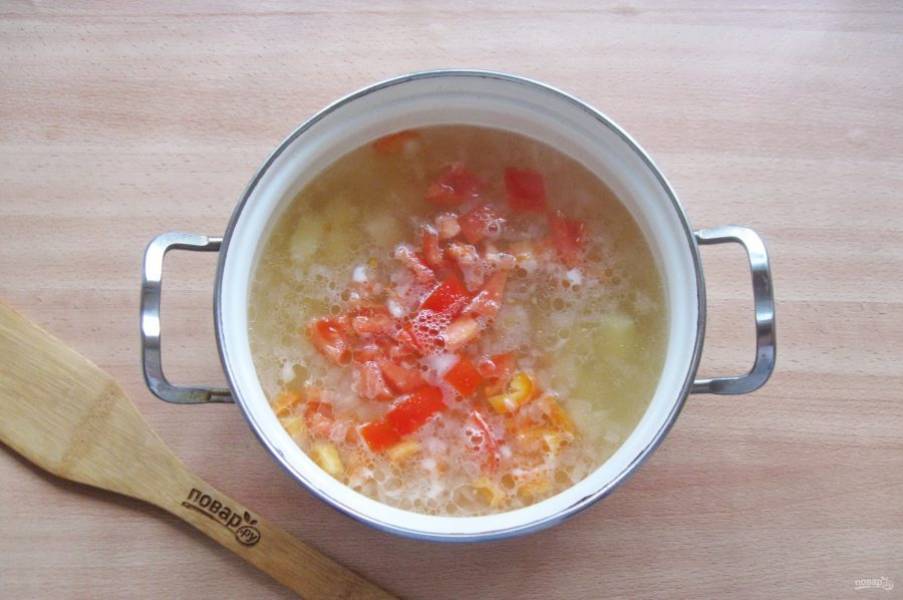 Через 10 минут приготовления супа болгарский перец и помидоры помойте. Перец очистите от семян. Нарежьте эти овощи кубиками и добавьте в кастрюлю.