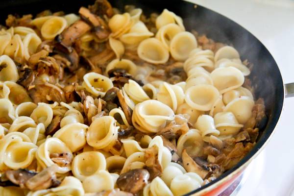 9. Если грибы под сливочным соусом в домашних условиях подаются с макаронами, как в данном случае, то, предварительно отварив, их можно сразу выложить на сковороду. 