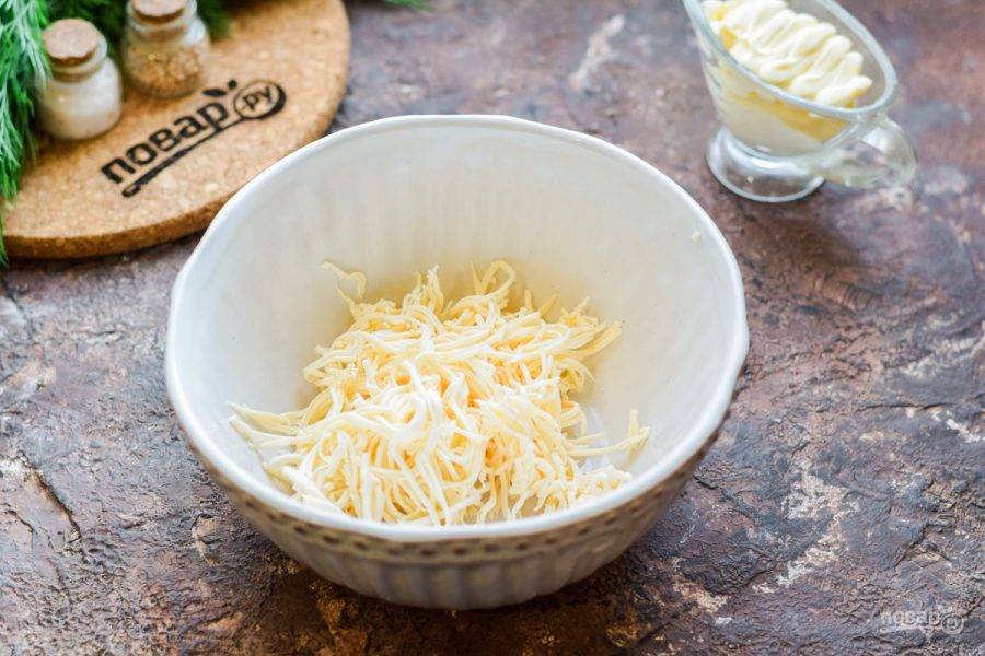 Плавленый сыр выбирайте сливочный или с любым вкусом — бекон, грибы, зелень. Натрите плавленый сыр на мелкой терке, переложите в салатник.