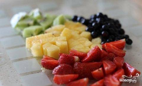 1.	Для нашего фруктового льда приготовим, прежде всего, ягоды и фрукты.  Кстати, набор ягод и фруктов можно изменить по вашему вкусу и желанию. Сюда подойдут любые ягоды и любые фрукты.  Промоем фрукты и ягоды. Клубнику нарезать нужно на четыре части. Ананас и киви нарежьте небольшими кубиками.