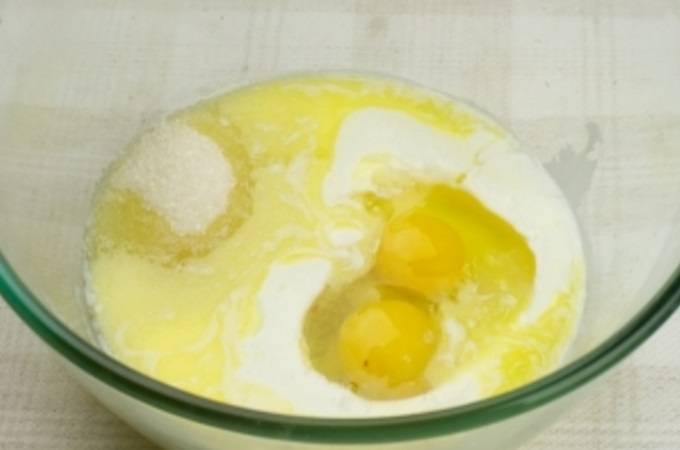 1.	Сливочное масло растопите, соедините с сахаром, кефиром и яйцами. Хорошо перемешайте до однородности.