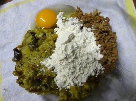 Теперь в глубокой миске смешиваем измельченную мякоть баклажанов, фарш, яйцо, муку, нарезанный мелко белый и зеленый лук, добавляем соль и молотый перец по вкусу.