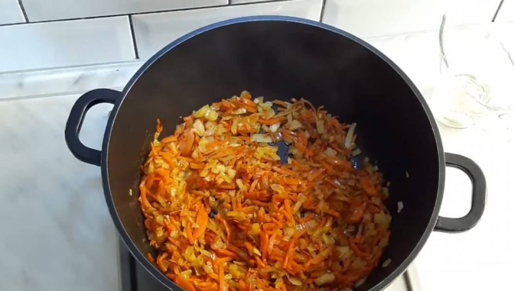 2. В кастрюле с толстым дном на растительном и сливочном масле обжарьте морковь, периодически помешивая. После этого (должно пройти примерно 4 минуты) добавьте лук. Жарьте, периодически помешивая, до полупрозрачности лука. 