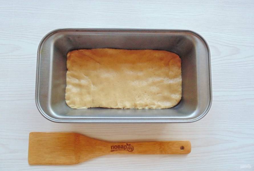 Одну треть теста выложите в форму для выпекания с пекарской бумагой. Распределите тесто по дну формы.