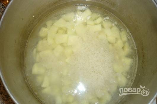 Рис промойте несколько раз. Залейте его и картошку водой. Варите вместе 15 минут.