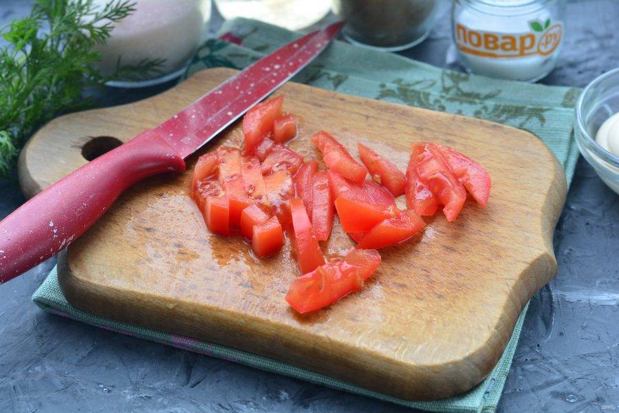 Нарежьте полосками помидоры.