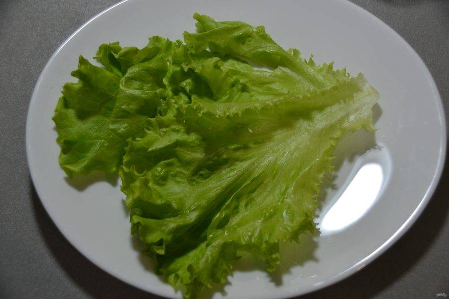 Выложите салатный лист на дно тарелки.